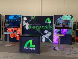 RENTAL: RE-2138 Inline Design with (3) Single-Sided Lightboxes, Including Bump-Out Panels, (2) RE-711 Charging Station Tables, (1) RE-1567 Backlit Reception Counter, (2) Large Monitor Mounts, SEG Backlit Fabric Graphics, and Vinyl Applied Graphics for Cha